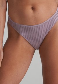 Violetti bikinin alaosa ruudullisella kuviolla, matala vyötärö ja sileä textuuri, suunniteltu minimaalista peittävyyttä varten.