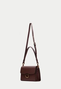 Brązowa skórzana torebka z teksturowaną powierzchnią, z klapką zamykaną na zatrzask, złotą okuciami i misternym przeszyciem wzdłuż krawędzi. Regulowany pasek.