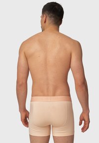 Peachfargede bomullsboksershorts med tettsittende passform, med en elastisk midje strikket med "INDICODE" og en glatt tekstur.