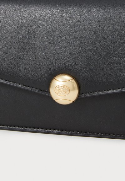 Portefeuille en cuir noir avec une finition texturée, doté d'une fermeture à bouton doré et de coutures le long des bords. Détail de logo en relief subtil.