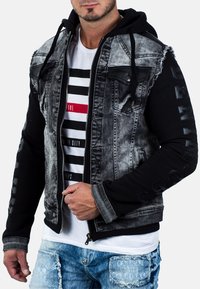 Giacca ibrida in denim e felpa con corpo in denim grigio a effetto usurato, maniche nere, chiusura con zip e dettagli logo sulle maniche.