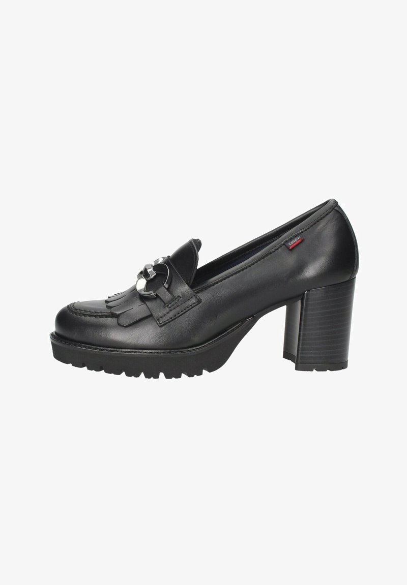 Mocasines de tacón en cuero negro con punta redonda, diseño con flecos en la parte delantera y detalle de hebilla metálica. Suela de goma texturada y resistente.