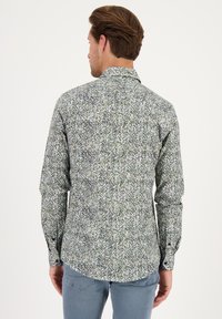 Hemd met een kraag en lange mouwen, voorzien van een groen-wit abstract patroon op een lichtgewicht stof. Slank gesneden met knoopmanchetten.