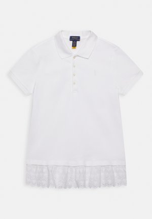 Polo blanco de algodón con cuello clásico, tapeta de cinco botones y detalle de encaje en el dobladillo con bordes ondulados y motivos florales.