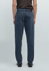 Jeans in denim blu scuro visti da dietro, con taglio dritto, due tasche posteriori e un'etichetta in pelle alla vita.