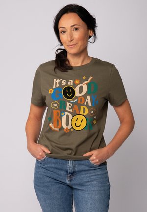 Olijfgroene katoen t-shirt met kleurrijke tekst en illustraties, waaronder boeken en glimlachende gezichten, met een ronde, crew neck ontwerp.