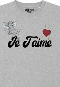 Camiseta de algodón gris con el texto negro "Je T'aime", un gráfico de un ángel contorneado y un corazón rojo con rayos.