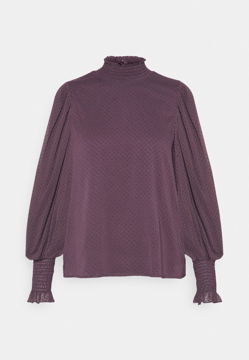 Blouse violette à manches longues avec col montant à volants, manches bouffantes, poignets froncés et texture subtile à pois.