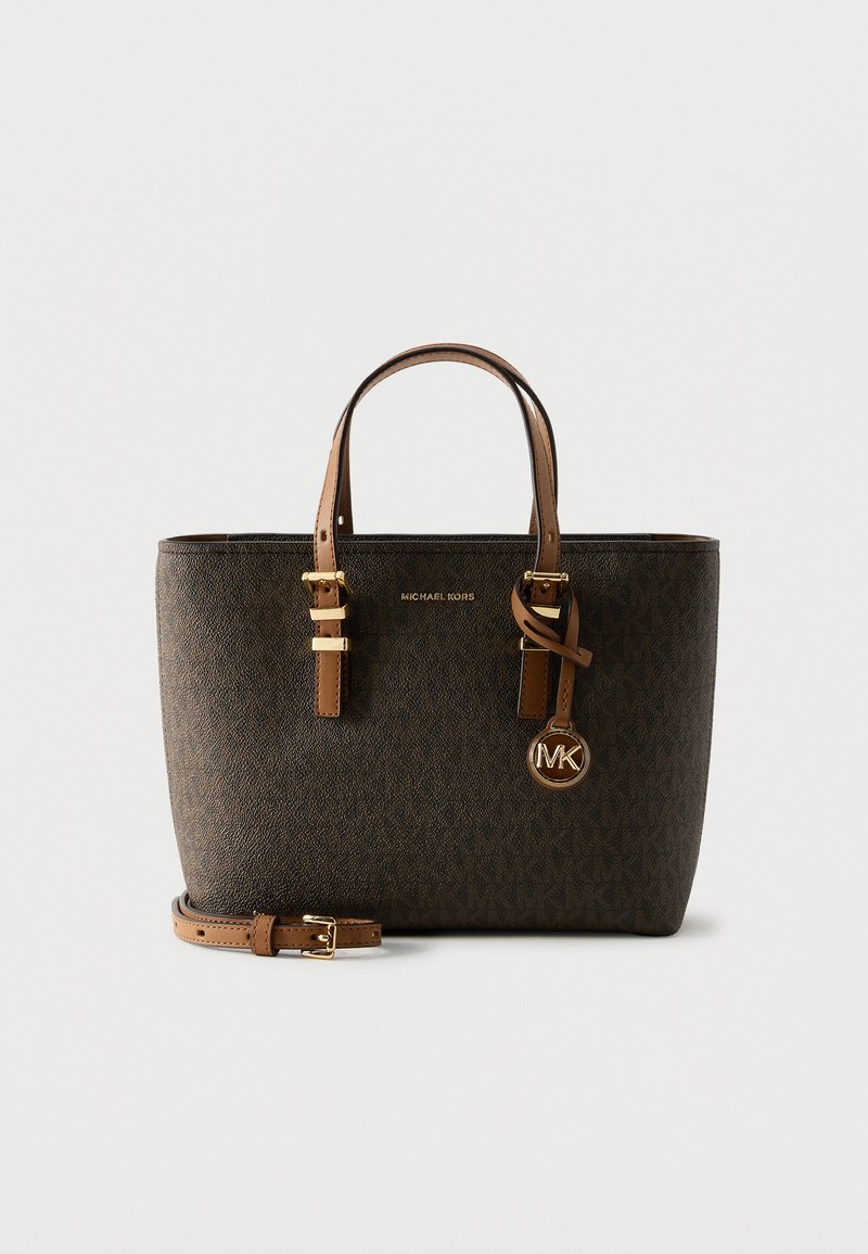 Σκούρο καφέ τσάντα Michael Kors tote με ανοιχτό καφέ λαβές, χρυσά εξαρτήματα και αποσπώμενο λουρί σε απλό λευκό φόντο.