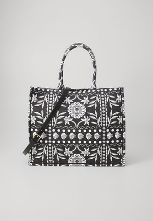 Schwarz-weiße, gemusterte Tragetasche mit zwei kurzen Griffen und einem abnehmbaren Schultergurt. Verfügt über florale und geometrische Designs.