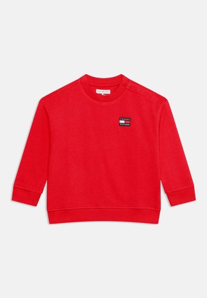 Sweat-shirt rouge à manches longues pour tout-petit avec poignets et ourlet côtelés, petit patch logo Tommy Hilfiger sur la poitrine et boutons-pression sur une épaule.
