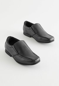 Chaussures en cuir noir au design élégant, avec un bout pointu et un style à enfiler. Détails de couture subtils et talons en caoutchouc bas.
