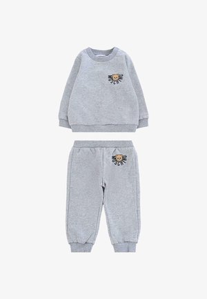 Szary komplet bluzki i spodni wykonany z miękkiego materiału. Bluzka ma grafikę misia z napisem; spodnie mają podobne detale. Elastyczne ściągacze.