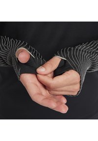 Schwarzes Langarmoberteil mit Daumenöffnungen, ausgestattet mit gerippten Bündchen mit weißen Akzenten und einem glatten, leicht strukturierten Stoff.