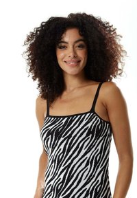 Black and white zebra-striped tank top with thin straps, featuring a ribbed texture and a fitted design.