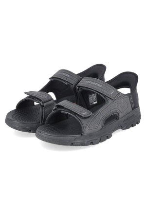 Zwarte Skechers sandalen met open teen, verstelbare klittenbandsluitingen, een gevoerd voetbed en robuuste zolen, ontworpen voor gebruik buitenshuis.