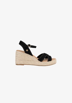 Sandalia cuña de tela negra con correa en el tobillo y hebilla, con suela de plataforma de cuerda trenzada beige.