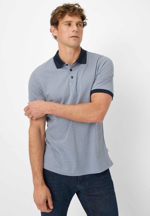 Short-sleeve polo shirt in blue and white geometric pattern, with navy collar and cuffs, featuring three-button placket and curved hem.