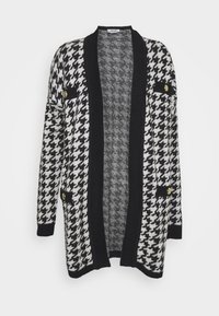 Zwart-wit houndstooth cardigan met een zwarte kraag, voorzakken en gouden knopen. Getextureerde stof met een open voorkant ontwerp.