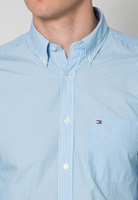 Hellblau karierte Button-Down-Hemd mit klassischem Kragen und einer Brusttasche, aus weichem Baumwollstoff hergestellt. Logo auf der Tasche.