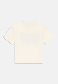 Camiseta de algodón crema con cuello redondo y mangas cortas. Presenta un detalle de texto desvanecido en la parte frontal, textura suave y ajuste relajado.