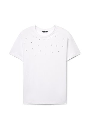 T-shirt bianca a maniche corte con decorazioni sparse di perle finte e cristalli sul davanti. Classico scollo rotondo, morbido tessuto in cotone.
