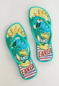 Šlepetės su turkio spalvos dirželiais, puoštos spalvingu tropiniu dizainu, kuriame pavaizduotas citrinos skonio Fanta skardinė, tukanas, palmės lapai, saulė ir vandens bangos.