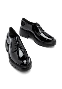 Pantofi lacți negri din piele patent, cu șireturi, având o talpă masivă din cauciuc, vârful rotunjit și detalii de cusătură minime. Finisaj neted.