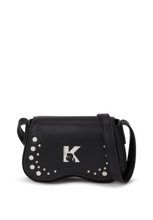 Melna mākslīgās ādas crossbody soma ar metalliskā logotipa akcentu, dekoratīvām baltām pynkām, izliekta forma un regulējama siksna.