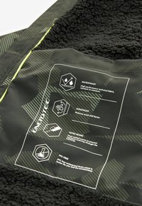 Pánska výkonová bunda s čiernym textúrovaným interiérom, vodoodolnou vonkajšou tkaninou s geometrickými vzormi a reflexnými prvkami pre lepšiu viditeľnosť.