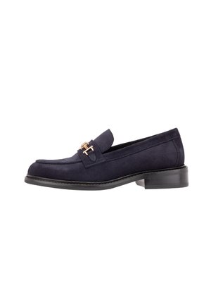 Mocassin en daim bleu marine avec un petit talon et un détail boucle en métal doré à l'avant, présenté de profil.