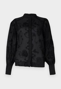 Blusa nera con motivo floreale ricamato, collo alto, polsini aderenti e chiusura con bottoni sul davanti. Tessuto trasparente con dettagli testurizzati.