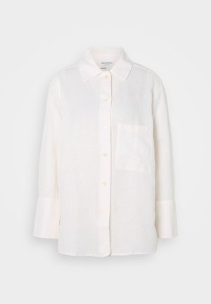 Balta, ilga rankovė liemenė su mygtukų apykakle. Turi priekinę kišenę ir laisvą, šiek tiek per didelį siluetą. Tekstūruotas audinys.