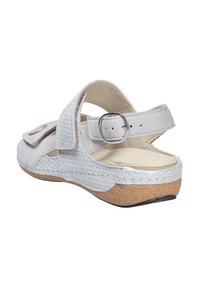 White open-back sandal with a textured strap, adjustable buckle, and cushioned insole. Cork sole adds stability and comfort.