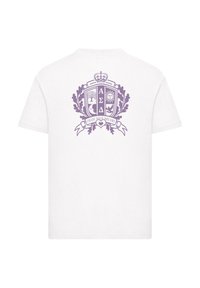 Camiseta blanca de algodón con un emblema morado en la parte trasera, con elementos decorativos que incluyen árboles, el sol y una inscripción en cinta.
