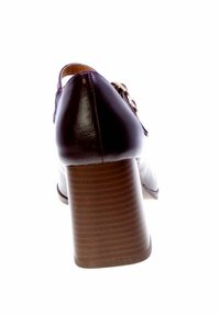 Tacco in pelle marrone con tacco in legno impilato. Il design presenta una superficie liscia e dettagli di cucitura sottili.