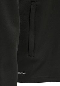 Tessuto nero con tasca laterale verticale e piccolo logo "BECOOL" vicino all'orlo inferiore.