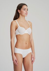 Reggiseno bianco a scacchi con accenti floreali sulle spalline, abbinato a slip bianchi a scacchi, con dettagli in pizzo in vita.
