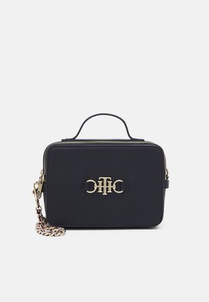 Zwarte rechthoekige crossbodytas met bovenhandvat, gouden ritssluiting, gouden kettingriem en gouden "TH" logo aan de voorkant.