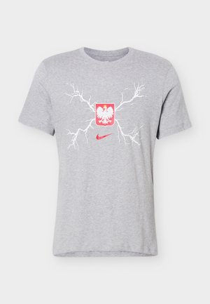 Hellgraues T-Shirt mit weißem Blitz-Design, rotem polnischem Adlerschild und rotem Nike-Swoosh-Logo, zentriert auf der Vorderseite.