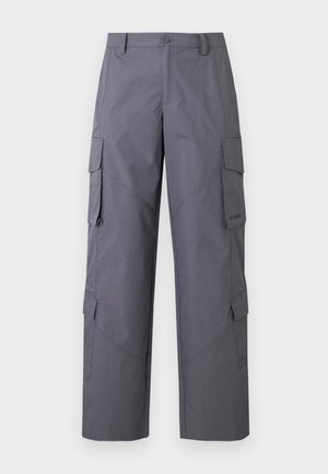 Pantalones cargo grises con un ajuste relajado, hechos de tela texturizada. Presentan múltiples bolsillos laterales y costuras reforzadas en las rodillas.