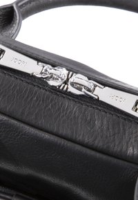 Čierna kožená kabelka s textúrovaným povrchom, obsahujúca strieborný zips, detail s logom a minimalistické dizajnové prvky.