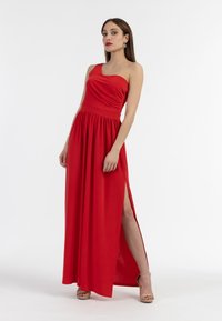 Abito rosso a spalla unica con corpetto arricciato e gonna fluida che presenta un alto spacco laterale. Tessuto morbido e vita aderente.