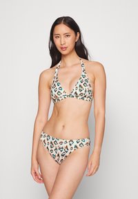Conjunto de biquíni com padrão de leopardo, apresentando um top de pescoço halter com copas triangulares e uma parte de baixo de corte baixo combinando. O material parece suave e elástico.