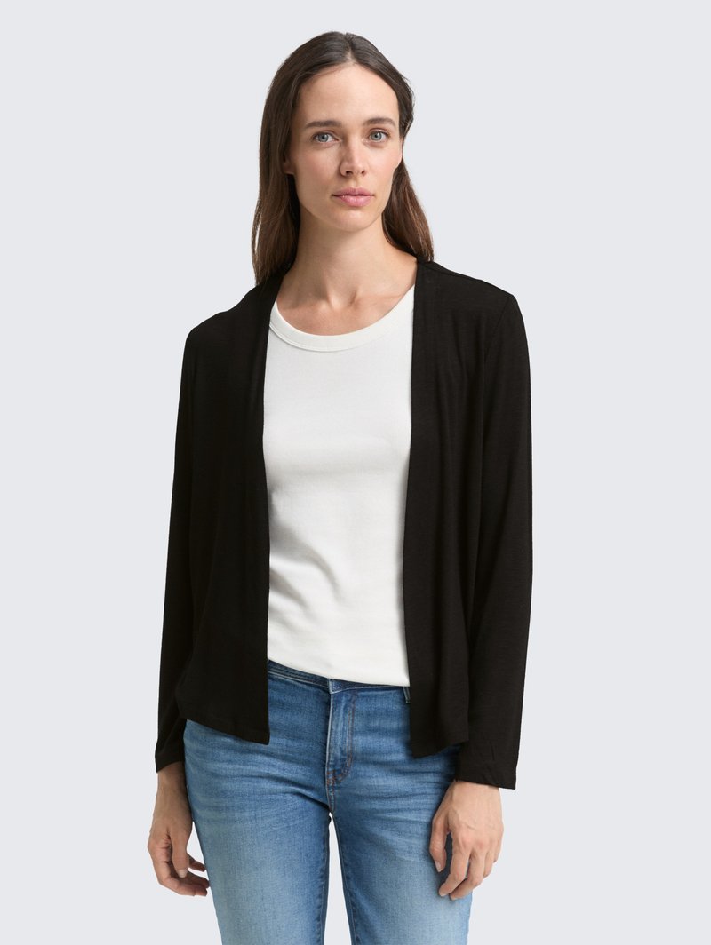 Zwarte lichtgewicht cardigan met een open voorkant, voorzien van lange mouwen. Gekocht bij een witte ronde hals top en blauwe spijkerbroek.