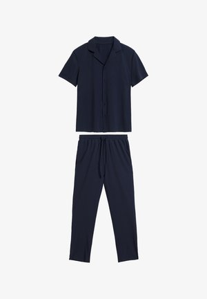 Granatowa koszula z krótkim rękawem i kołnierzykiem zapinana na guziki, w połączeniu z dopasowanymi spodniami na sznurku, wykonanymi z miękkiej, gładkiej tkaniny.