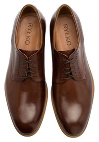 Brązowe skórzane buty eleganckie o gładkim wykończeniu, z detalami w stylu brogue, klasycznym zapięciem na sznurowadła oraz beżową gumową podeszwą.