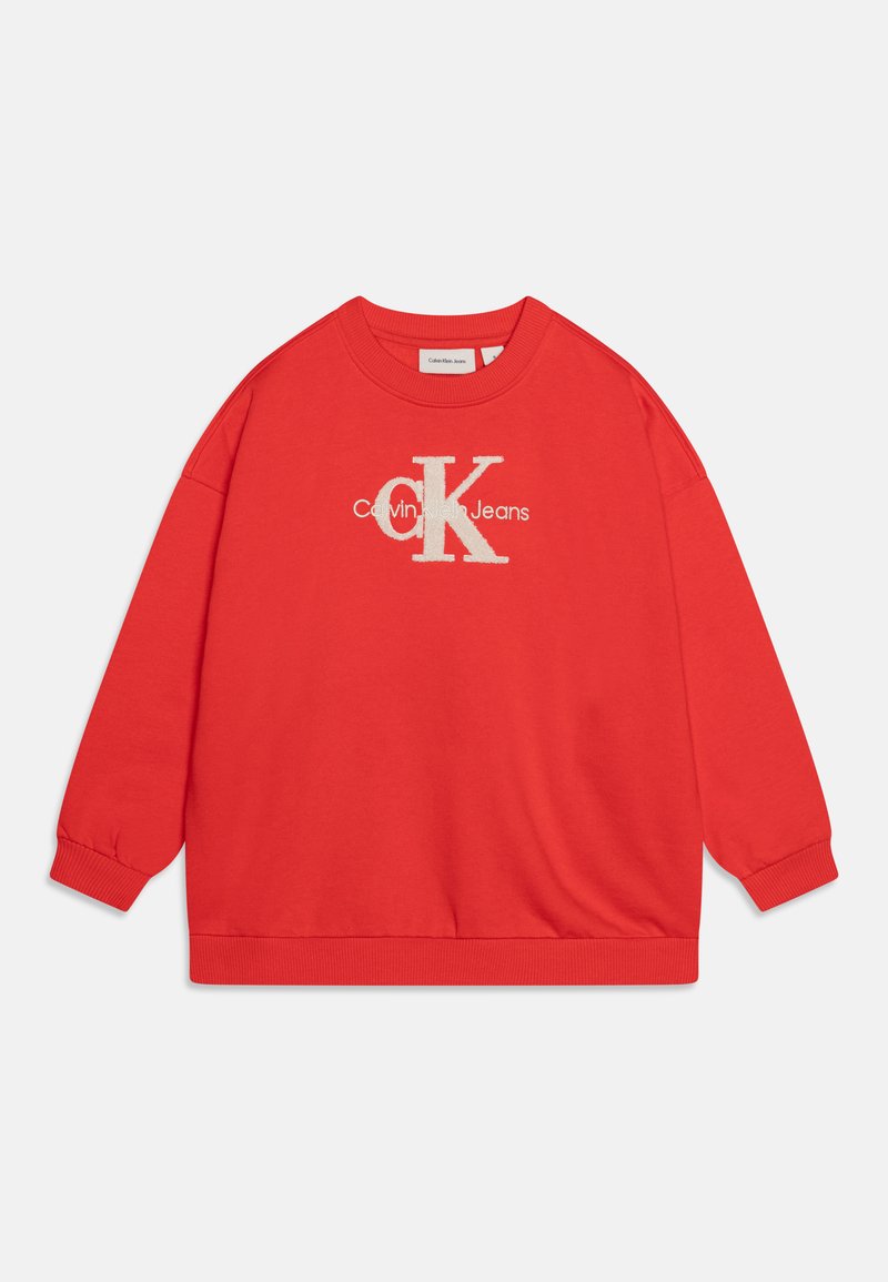 Röd sweatshirt med rund hals och oversized passform. Har vit "Calvin Klein Jeans" logga och ribbade muddarna. Slät bomullstyg.
