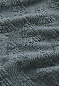 Textured fabric in muted teal, featuring an embossed pattern of Christmas trees, giving a tactile, woven appearance.