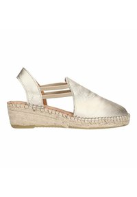 Metallic gouden espadrille-wedge met een leren bovenkant met textuur, elastische bandjes en een met jute gewikkelde zool. Rondneus en lage hoogte.